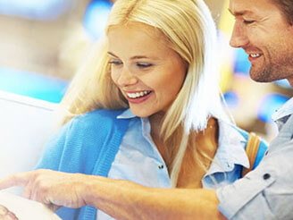 男人指着平板电脑上的屏幕向女人展示信息